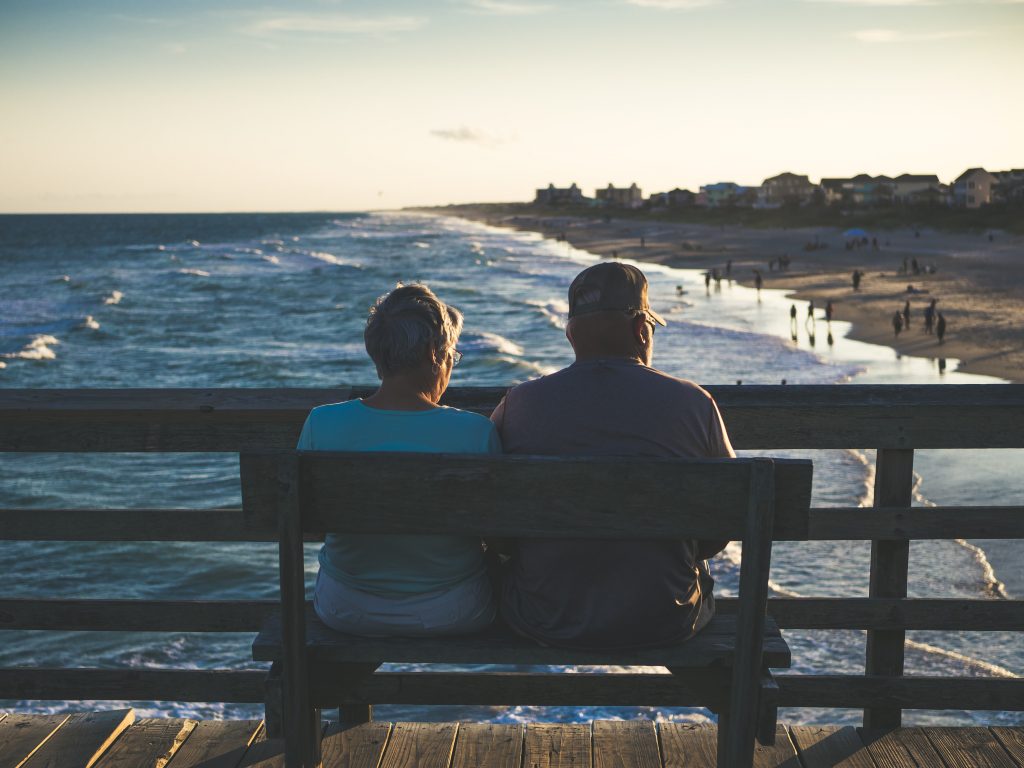 Retired man and woman sitting on bench